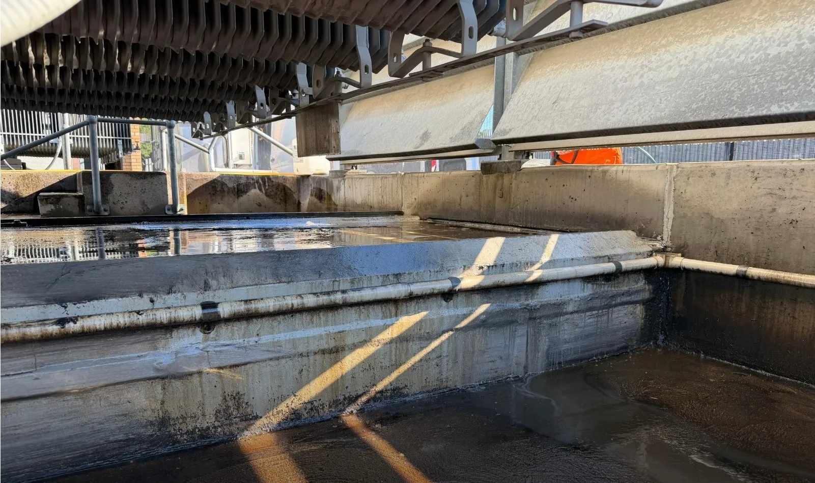 Oil-stained concrete bund walls and plinth beneath a transformer radiator bank, before remediation.