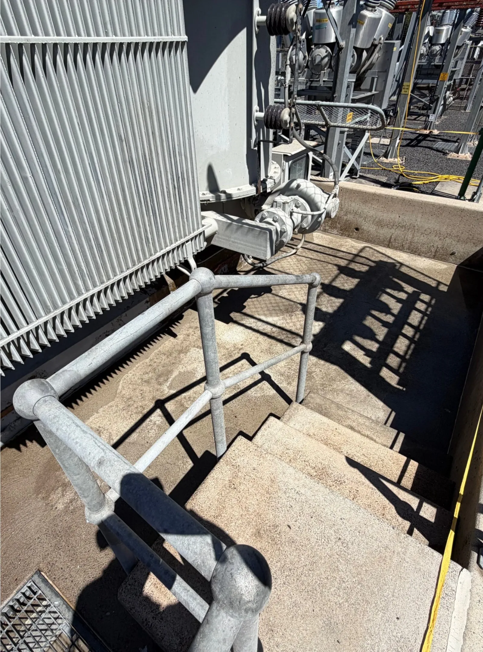 A prepared concrete bund slab and steps beside a transformer, ready for lining.
